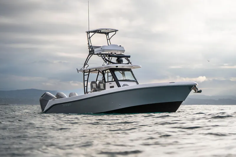 Slide: The Image of 2024 Everglades 365 Center Console boat on open water under cloudy sky. - 43