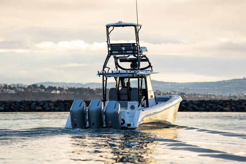 Slide: The Image of 2024 Everglades 365 Center Console boat cruising on calm water at sunset. - 5