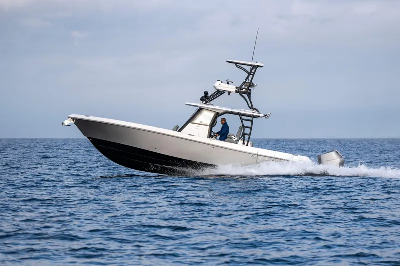 Slide: The Image of 2024 Everglades 365 Center Console boat cruising on open water. - 58