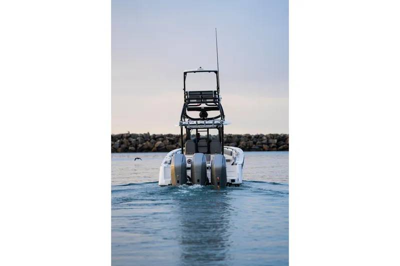 Slide: The Image of 2024 Everglades 365 Center Console boat on water, rear view with triple engines. - 6