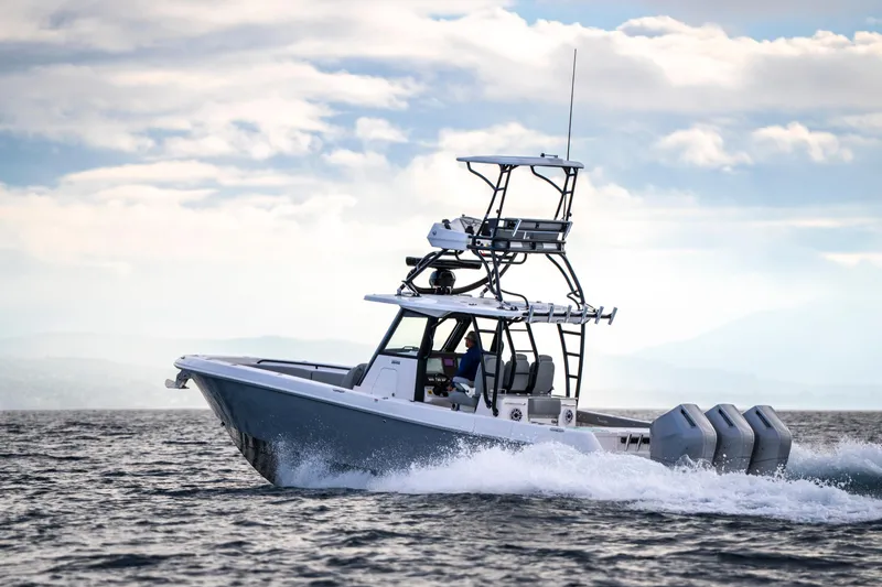 Slide: The Image of 2024 Everglades 365 Center Console boat cruising on open water under cloudy sky. - 64