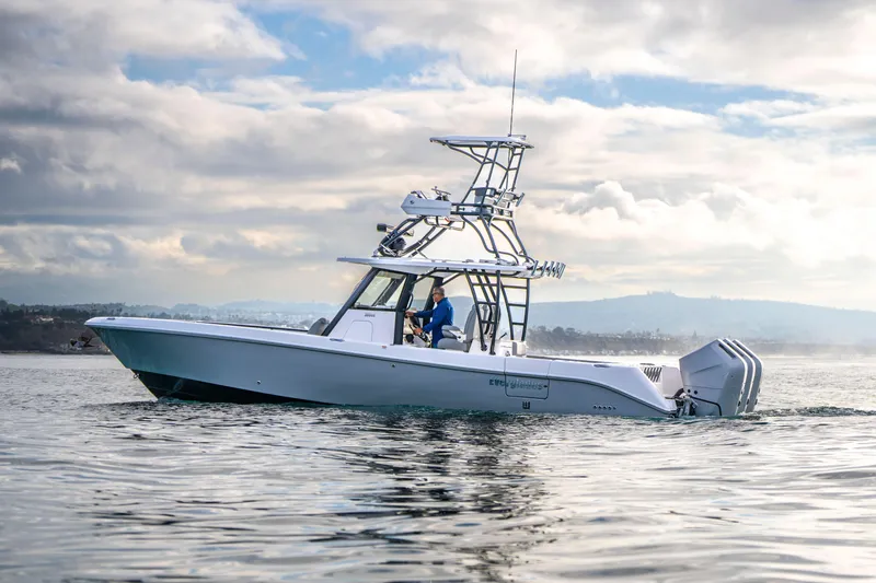 Slide: The Image of 2024 Everglades 365 Center Console boat cruising on calm waters under cloudy skies. - 71