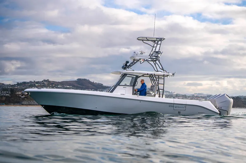 Slide: The Image of 2024 Everglades 365 Center Console boat cruising on calm waters under cloudy skies. - 72