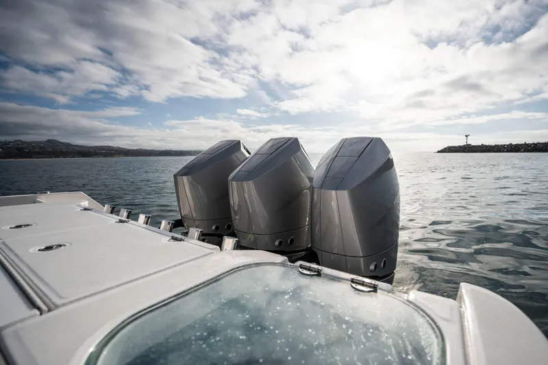 Slide: The Image of 2024 Everglades 365 Center Console boat with triple outboard engines on open water. - 74