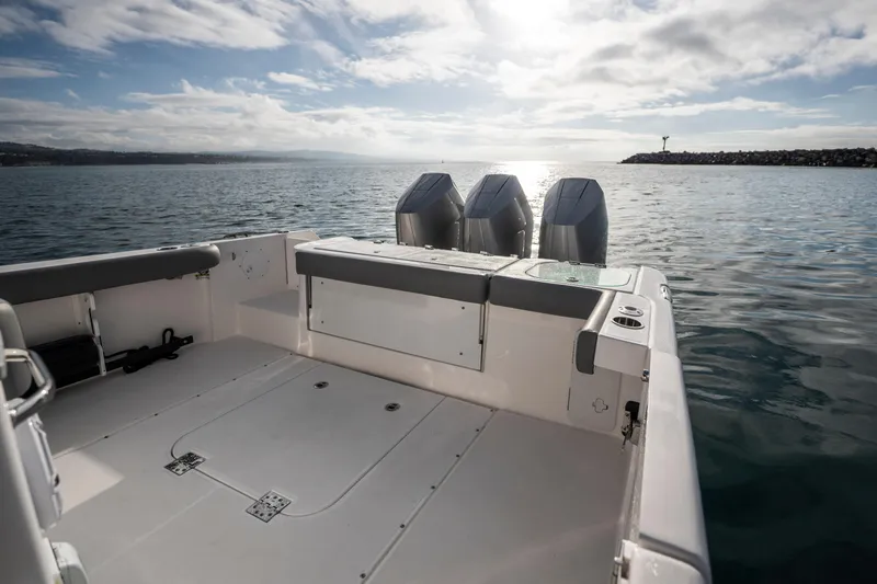 Slide: The Image of 2024 Everglades 365 Center Console boat with triple engines on calm water. - 76