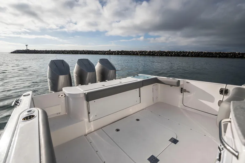 Slide: The Image of 2024 Everglades 365 Center Console boat with triple engines, spacious deck, and scenic ocean view. - 77