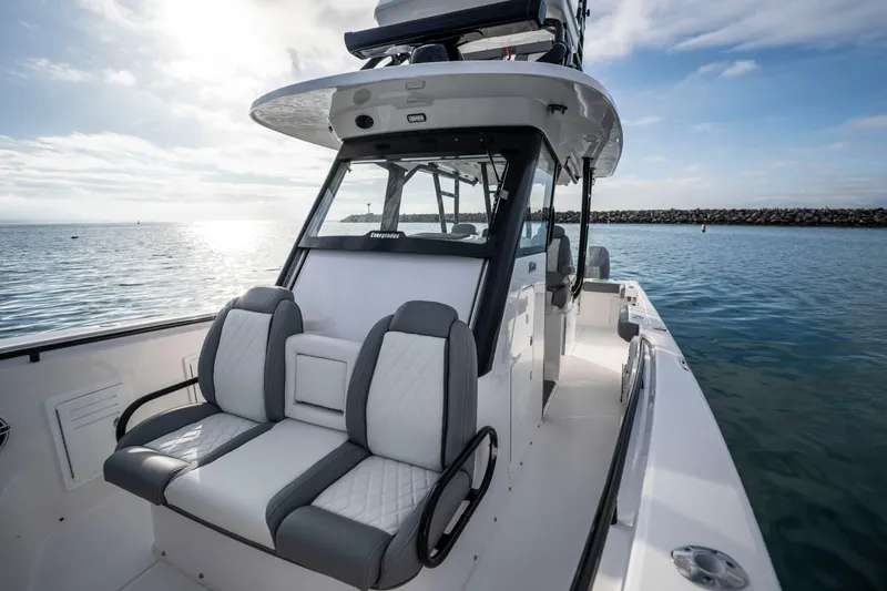 Slide: The Image of 2024 Everglades 365 Center Console boat on calm water, featuring sleek seating and modern design. - 89
