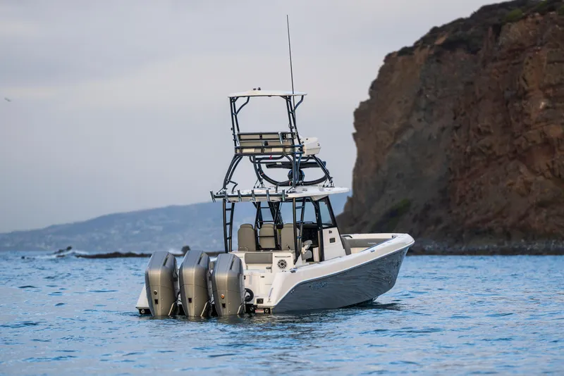 Slide: The Image of 2024 Everglades 365 Center Console boat on water near rocky coastline. - 9