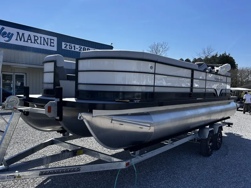 Slide: The Image of 2026 Veranda Vista Series TRITOON-150HP on trailer outside marine shop. - 2