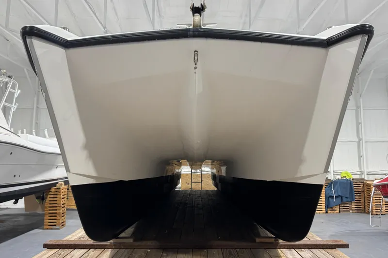 Slide: The Image of 2003 Glacier Bay 2640SX Renegade catamaran in storage, front view. - 10