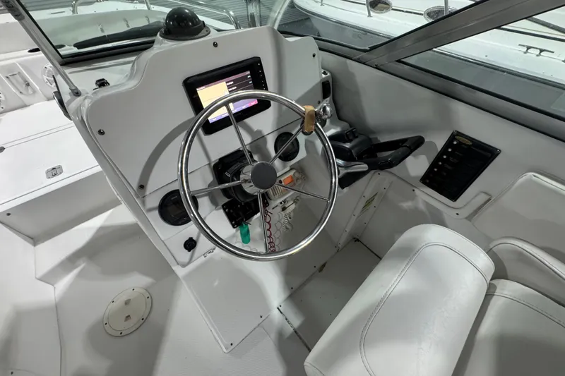 Slide: The Image of 2003 Glacier Bay 2640SX Renegade boat cockpit with steering wheel and control panel. - 14