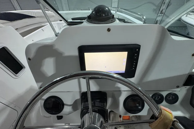 Slide: The Image of Steering console of 2003 Glacier Bay 2640SX Renegade with navigation display and compass. - 16