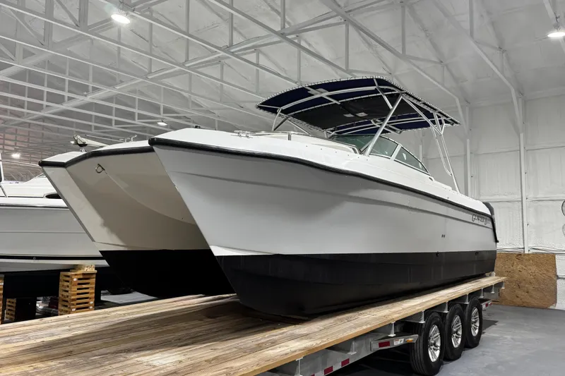 Slide: The Image of 2003 Glacier Bay 2640SX Renegade catamaran in indoor storage on a trailer. - 2