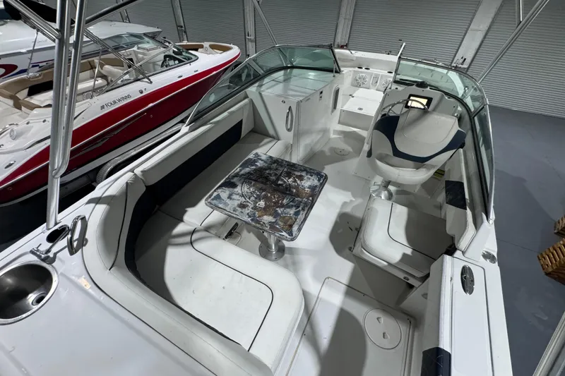 Slide: The Image of 2003 Glacier Bay 2640SX Renegade boat interior with seating and table in a showroom. - 20