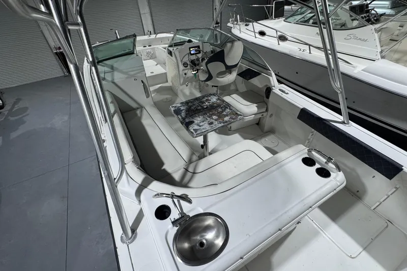 Slide: The Image of 2003 Glacier Bay 2640SX Renegade boat interior with seating, steering console, and sink. - 23
