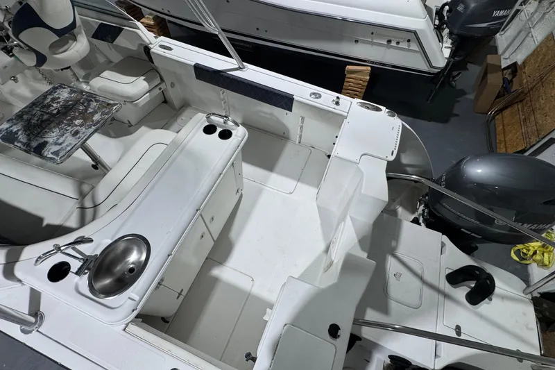 Slide: The Image of 2003 Glacier Bay 2640SX Renegade boat interior with seating, sink, and Yamaha outboard motor. - 24