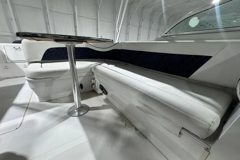 Slide: The Image of Interior seating of 2003 Glacier Bay 2640SX Renegade boat with table in a bright setting. - 26