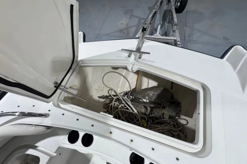 Slide: The Image of Open storage compartment on 2003 Glacier Bay 2640SX Renegade boat, containing ropes and anchor. - 33
