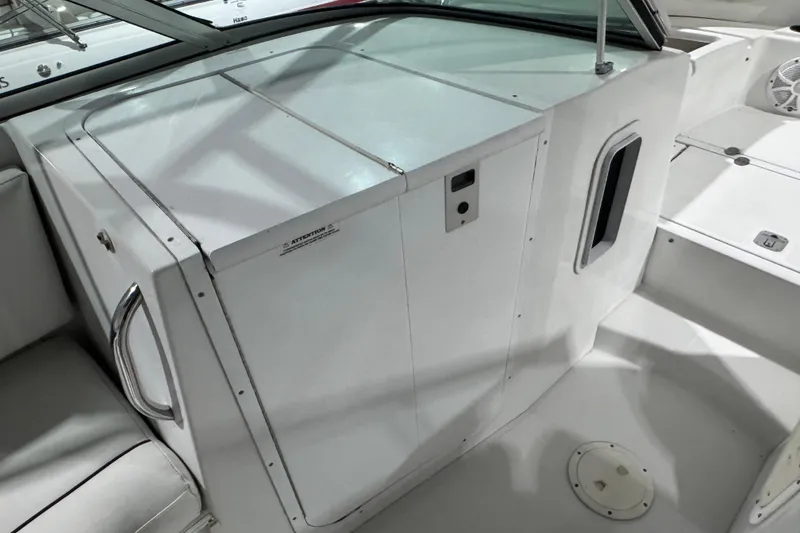 Slide: The Image of 2003 Glacier Bay 2640SX Renegade boat interior with white seating and storage area. - 35