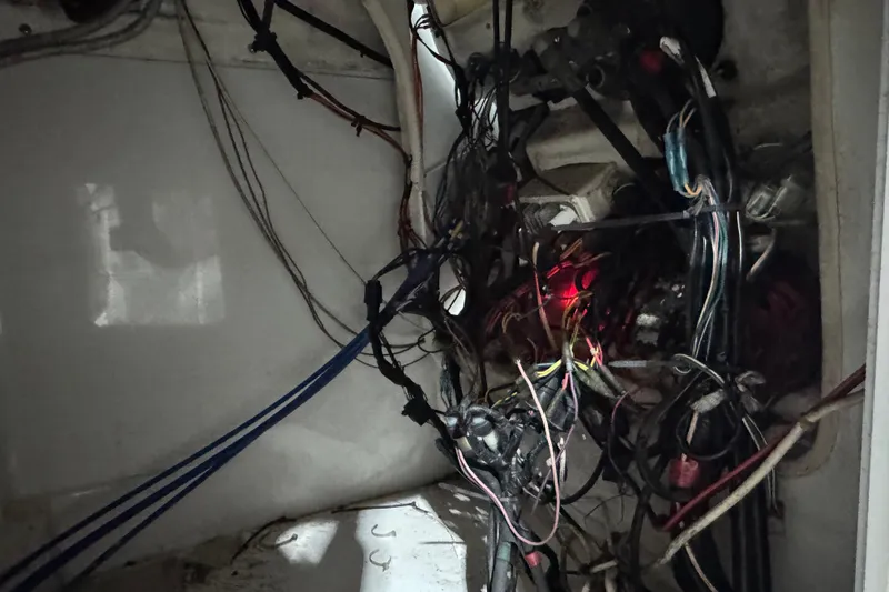 Slide: The Image of Tangled wiring inside a 2003 Glacier Bay 2640SX Renegade boat, highlighting electrical complexity. - 45