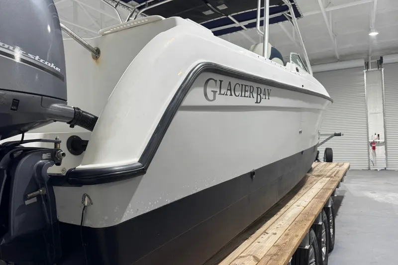 Slide: The Image of 2003 Glacier Bay 2640SX Renegade boat in indoor storage on trailer. - 8