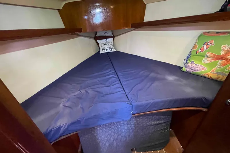 Slide: The Image of Cozy cabin interior of 2006 Hunter 36 sailboat with blue bedding and decorative pillow. - 10