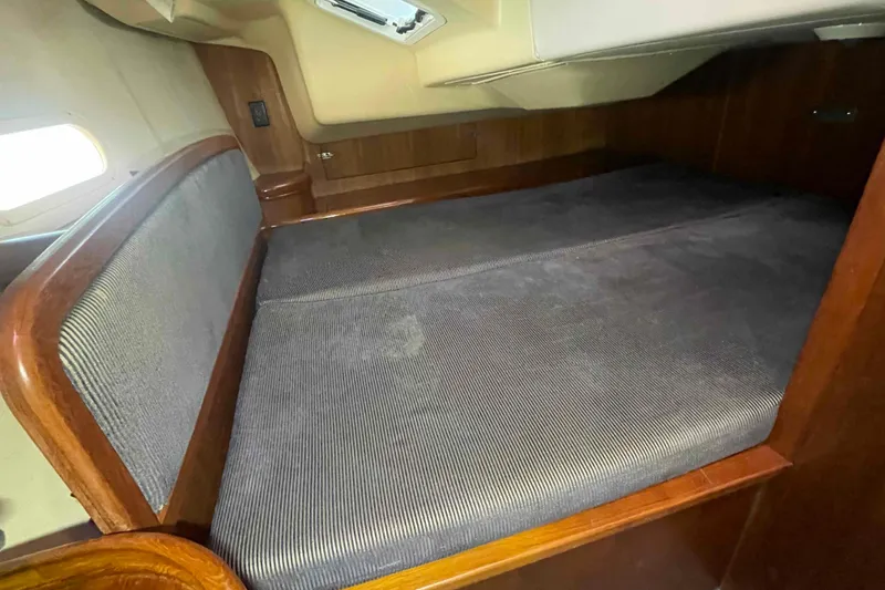 Slide: The Image of Cozy cabin interior of 2006 Hunter 36 sailboat with wooden accents and cushioned seating. - 11