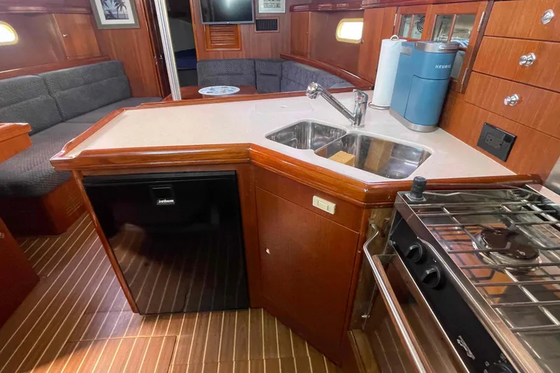 Slide: The Image of 2006 Hunter 36 yacht interior kitchen with sink, stove, and refrigerator. - 27