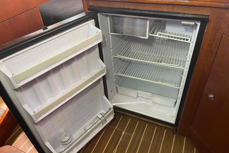 Slide: The Image of Open refrigerator in 2006 Hunter 36 yacht, showing empty shelves and a water bottle. - 28
