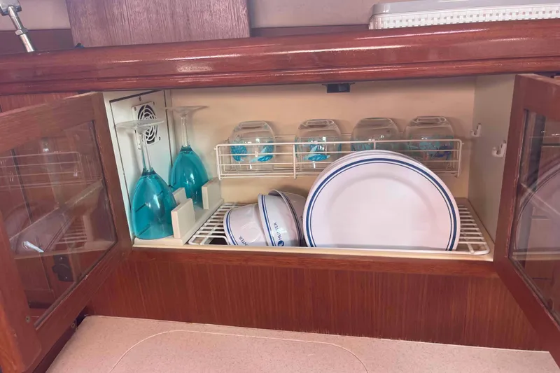 Slide: The Image of Wooden cabinet in a 2006 Hunter 36 yacht, storing glassware and plates neatly. - 33