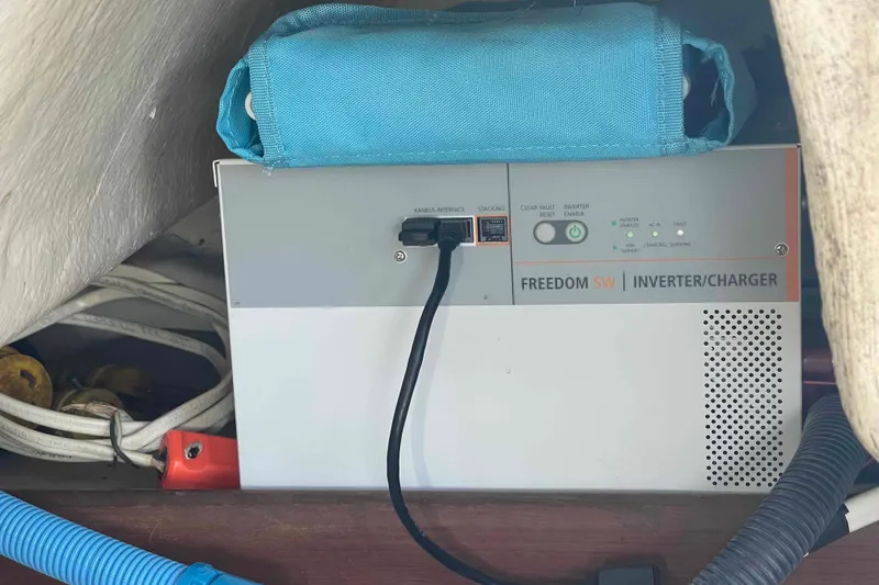 Slide: The Image of Inverter/charger in 2006 Hunter 36 boat, surrounded by cables and a blue bag. - 44