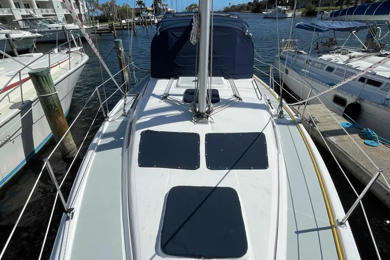 Slide: The Image of 2006 Hunter 36 sailboat docked at marina, featuring sleek deck design. - 49