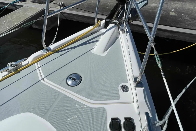 Slide: The Image of Bow of a 2006 Hunter 36 sailboat docked, featuring deck fittings and railings. - 53