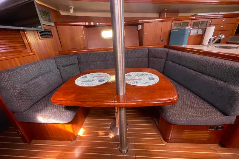 Slide: The Image of Cozy interior of 2006 Hunter 36 sailboat with wooden table and cushioned seating. - 6