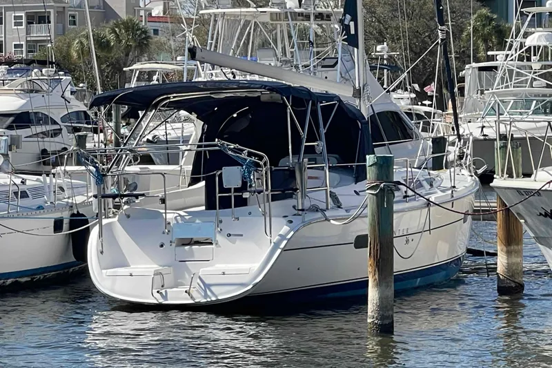 Slide: The Image of 2006 Hunter 36 sailboat docked in a marina, surrounded by other boats. - 60
