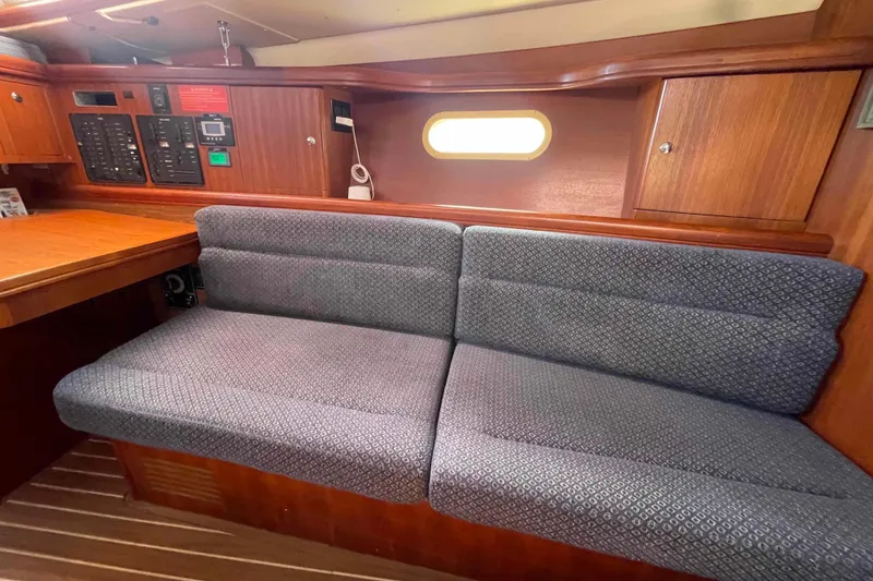 Slide: The Image of Interior of 2006 Hunter 36 sailboat with cushioned seating and wooden cabinetry. - 8
