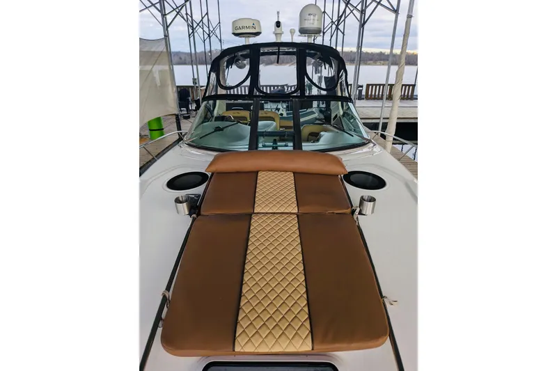 Slide: The Image of 2002 Sea Ray Sundancer 320 with brown cushioned deck, docked under a canopy. - 20