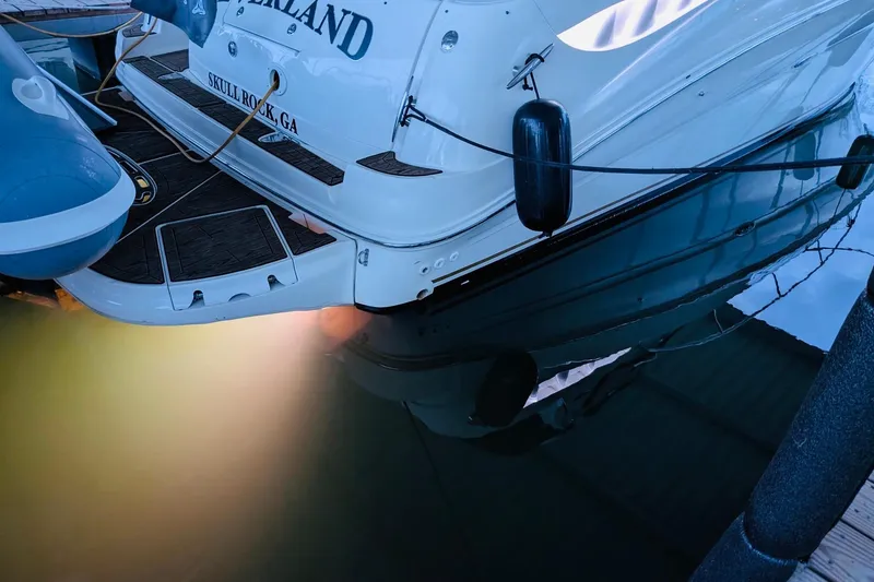 Slide: The Image of 2002 Sea Ray Sundancer 320 docked, rear view with underwater lights reflecting in water. - 28