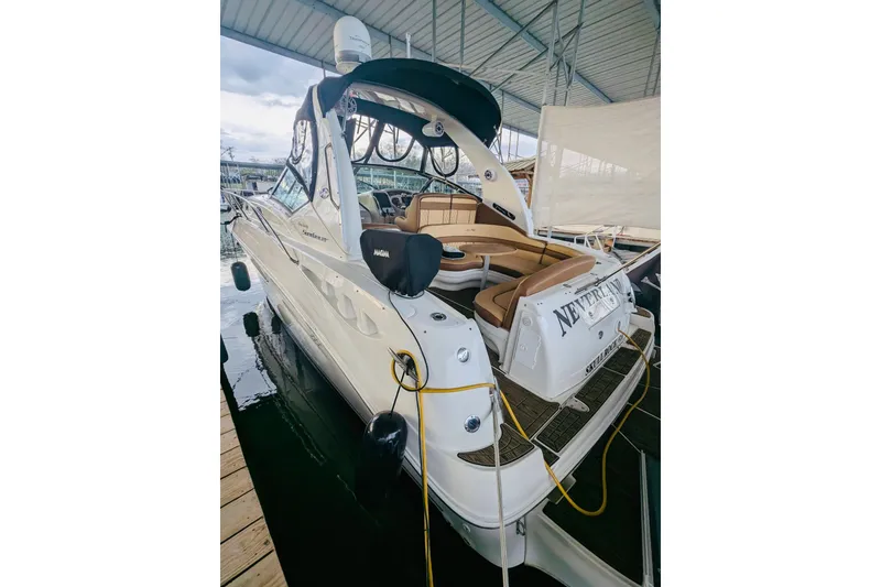 Slide: The Image of 2002 Sea Ray Sundancer 320 docked, featuring spacious seating and sleek design. - 3