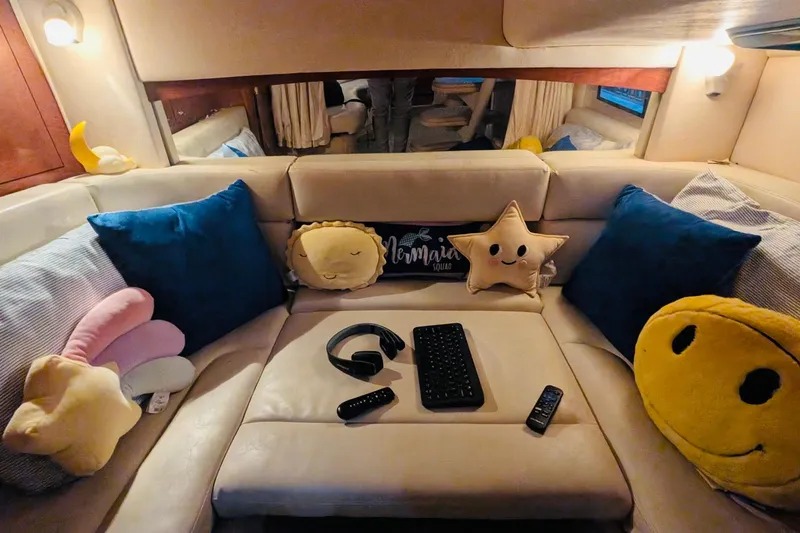 Slide: The Image of Cozy interior of 2002 Sea Ray Sundancer 320 with plush pillows and entertainment setup. - 34