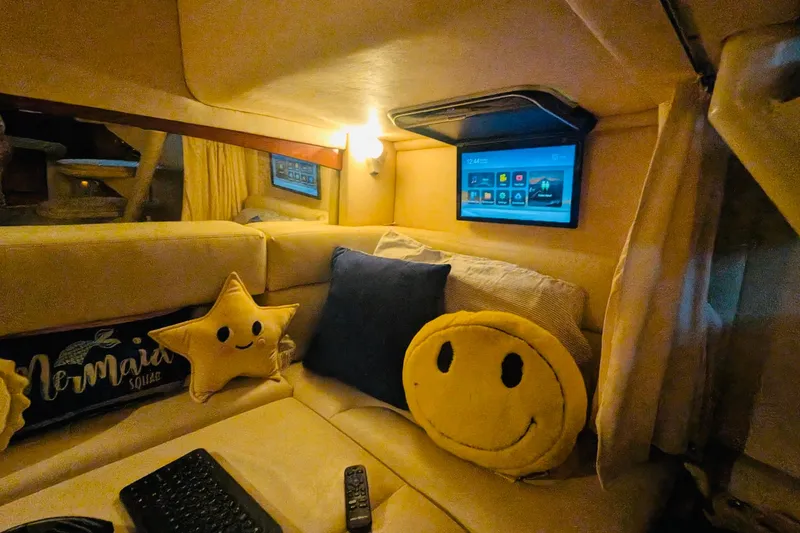 Slide: The Image of Cozy interior of 2002 Sea Ray Sundancer 320 with plush pillows and wall-mounted screen. - 36