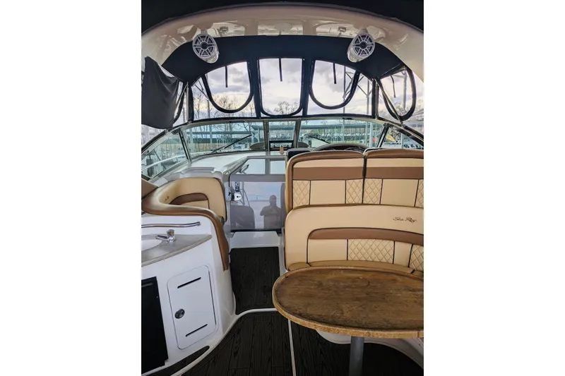 Slide: The Image of 2002 Sea Ray Sundancer 320 interior with beige seating and wooden table. - 4