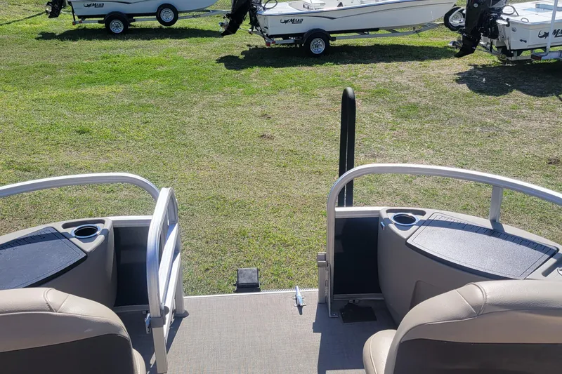Slide: The Image of 2023 Sun Tracker Bass Buggy 18 DLX pontoon boat interior with cup holders and seating. - 10