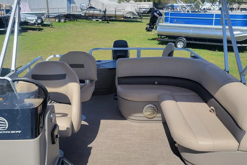 Slide: The Image of 2023 Sun Tracker Bass Buggy 18 DLX pontoon boat interior with beige seating. - 11