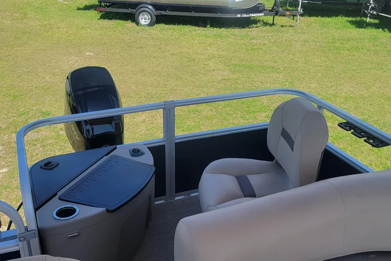 Slide: The Image of 2023 Sun Tracker Bass Buggy 18 DLX pontoon boat interior with seating and motor. - 6