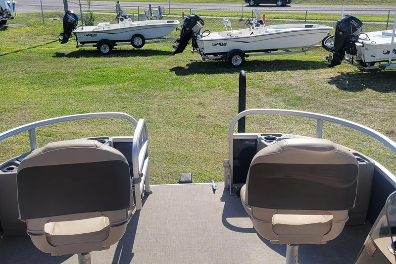 Slide: The Image of 2023 Sun Tracker Bass Buggy 18 DLX pontoon boat interior with two seats, parked on grass. - 9