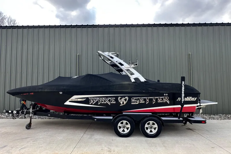 Slide: The Image of 2012 Malibu Wakesetter 22 MXZ boat with cover, parked on trailer. - 16