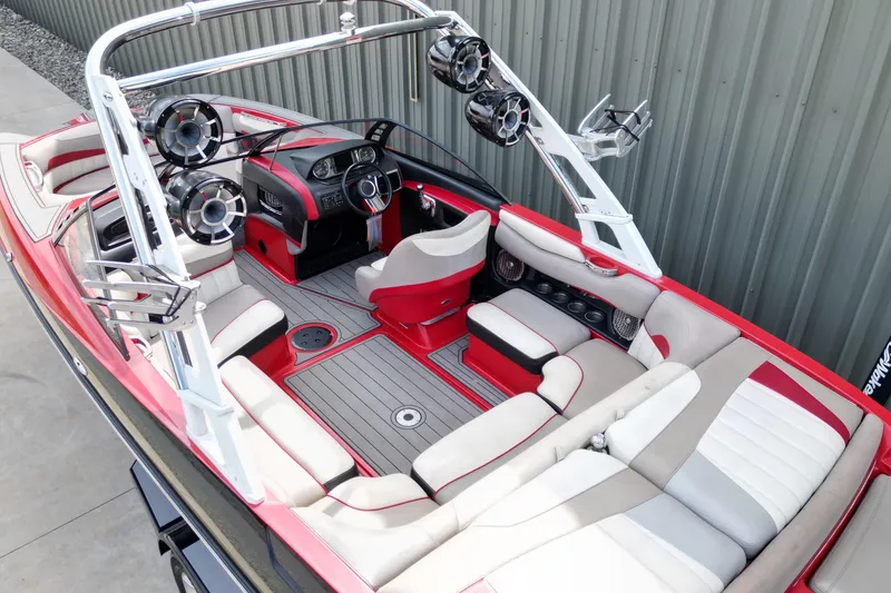 Slide: The Image of 2012 Malibu Wakesetter 22 MXZ boat interior with red and white seating, speakers, and steering console. - 5