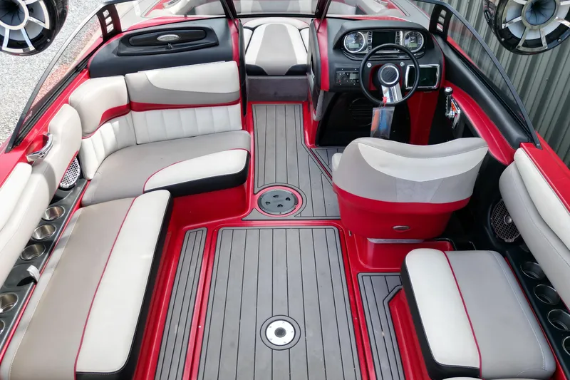 Slide: The Image of 2012 Malibu Wakesetter 22 MXZ interior with red and white seating, modern dashboard, and sleek design. - 7