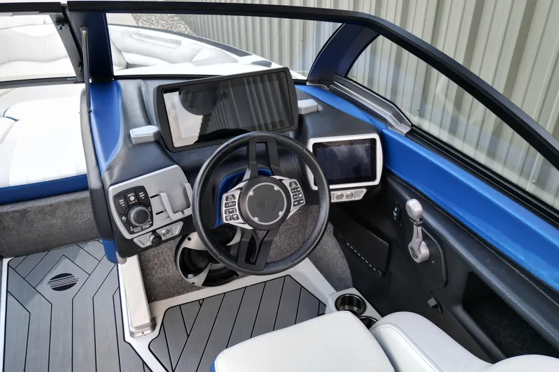 Slide: The Image of 2017 Malibu Wakesetter 25 LSV boat dashboard with modern controls and steering wheel. - 8